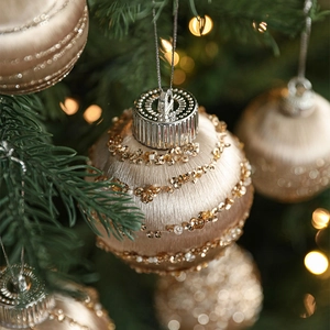 Champagne gold Christmas ball ornaments with glitter spirals and beads on a festive tree