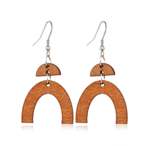 Detail of geometric cutout brown wood earrings with half-round and arched wooden pieces
