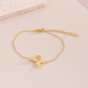 Detailed macro shot of gold stainless steel four-leaf clover bracelet with zircon