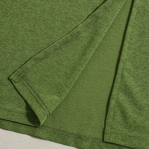 Detail of green knit dress showing high-quality stitching and textured split hem fabric