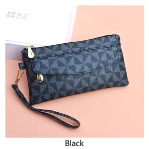 Detail of checkered PU leather handbag with gold zipper and a wristlet strap