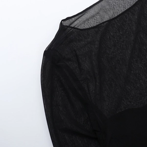 Détail du tissu en maille noire transparente montrant l'encolure et la texture du haut