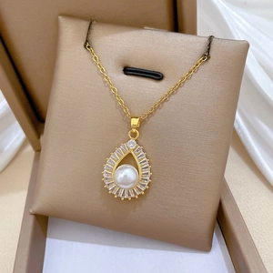 Macro shot of gold teardrop pearl pendant necklace with crystals in a jewelry gift box