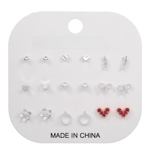 Detail view of 12 pairs of geometric stud earrings set on a white fashion jewelry card