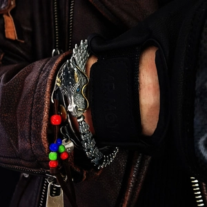 Retro silver dragon cuff bracelet and colorful beaded wristband on a dark leather jacket