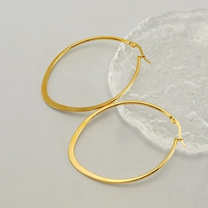Minimalist 18k gold plated stainless steel oval hoop earrings on a glass plate