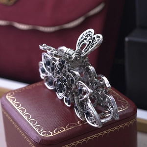 Close-up of vintage silver floral hair claw with blue rhinestones on a luxury gift box