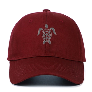 Macro detail of high-quality cotton turtle embroidery on a burgundy baseball cap
