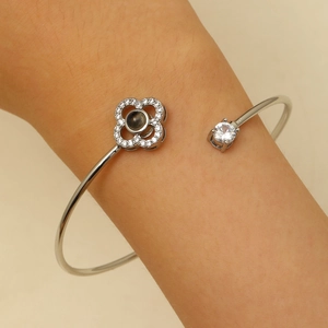 Détail du bracelet de projection trèfle en argent avec pavé de zircons blancs au poignet