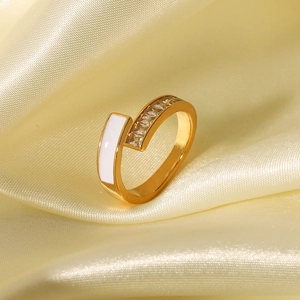 Asymmetrischer 18K vergoldeter Ring mit weißer Emaille und Zirkonia auf Seidenhintergrund