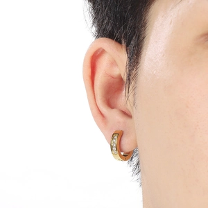 Close-up of golden stainless steel hoop earrings with five clear cubic zirconia stones