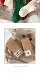 Détail de chaussettes de Noël en coton dans une boîte cadeau en kraft au design festif
