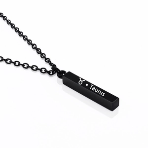Detailed macro view of matte black Taurus zodiac bar pendant with engraved symbol