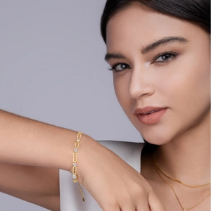 Gold paperclip link bracelet for women featuring round white zircon stones on model's wrist