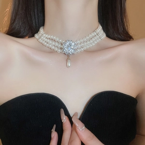 Close-up of triple-layer pearl choker necklace featuring floral rhinestone and drop pearl