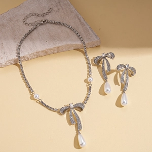Parure de bijoux avec nœud argenté, strass étincelants et pendentifs perles gouttes