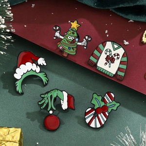 Detailed close-up of festive Christmas enamel pins with Grinch and holiday motifs