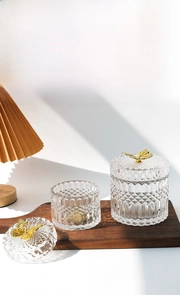 Detail of French vintage embossed glass jars with elegant golden butterfly lids on wood