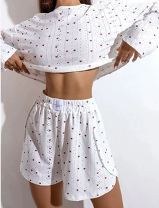 Detail of breathable eyelet embroidery and red heart prints on white loungewear set