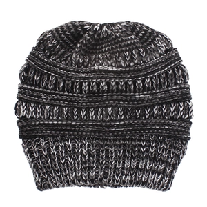 Close-up of mixed black, grey, and white knit texture on a cozy winter ponytail beanie