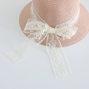 Pink woven straw hat for girls featuring delicate white lace bow and floral embroidery