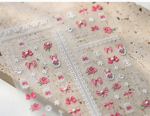 Detailed view of Korean style nail art stickers with elegant pink bows and white lace