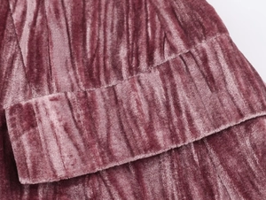 Detailed macro view of pleated velvet fabric in dusty rose with soft light and texture