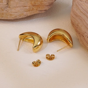 Polished gold semi-hoop stud earrings set on a natural stone minimalist background