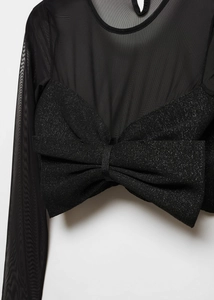 Détail d'un haut en maille noire transparente avec un grand nœud pailleté et brillant