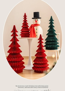 Detail of red and green honeycomb paper Christmas trees and a snowman table decoration