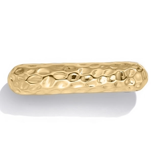 Close-up of golden hair clip with hand-hammered texture and metallic glossy finish