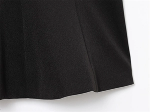 Detailed close-up of hem stitching and fine woven texture of black strapless top
