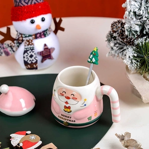 Detail view of pink Santa ceramic mug with festive lid and Christmas tree spoon set