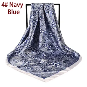 Detailed close-up of navy blue paisley pattern on large satin square head scarf