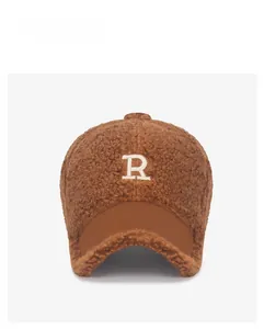 Close-up of brown teddy fleece baseball cap with white embroidered letter R on front
