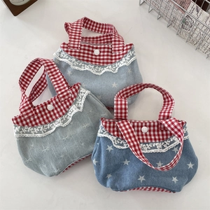 Dettaglio di pizzo dolce e motivi a quadretti rossi e bianchi su borse in denim colorate