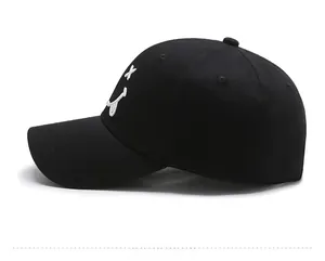 Side view of black cotton baseball cap with white embroidered smiley face and curved brim