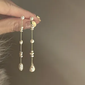 Detailed macro of French vintage baroque pearl tassel earrings with fine gold chain
