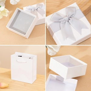 Elegant white square jewelry gift box with gray ribbon bow and matching gift paper bag