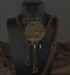 Macro detail of gold-plated necklace set with sparkling CD logo and cuban chain