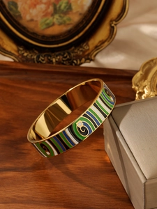 Detail of vintage enamel bangle with colorful geometric patterns on a jewelry box