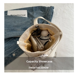 Top view of straw bucket bag interior showing large capacity for umbrella and phone