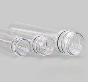 Macro detail of three transparent PET plastic tube preforms with precise screw thread necks