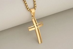 Detailed view of hollow 3D stainless steel cross pendant with golden box chain