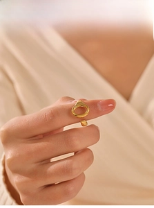 Detailed view of adjustable gold-plated oval ring worn on model with elegant styling