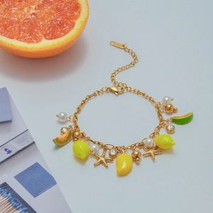 18K gold plated stainless steel bracelet with lemon charms and pearls on a grapefruit setup