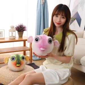 Détail montrant des peluches de poisson-globe en rose et vert avec texture douce