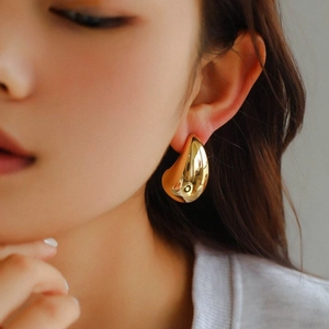 18K gold plated teardrop earrings with mirror polished finish worn by a female model