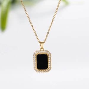 Detail showing a gold necklace with a black rectangular pendant and white zircon border
