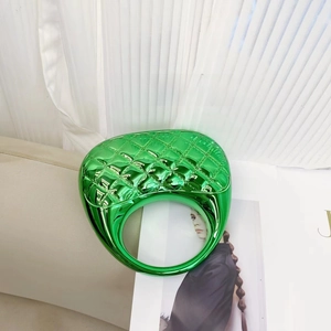 Close-up of vibrant green metallic ring featuring a quilted diamond lattice texture
